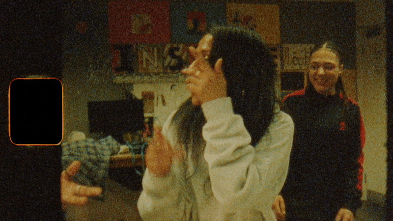 GIF moving image of woman laughing and trying to cover her face from the camera
